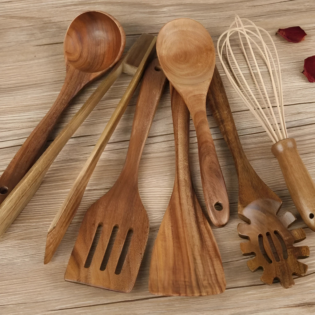 Seven wooden cooking spoons and spatulas with non-slip handles arranged as a set for non-stick pans.