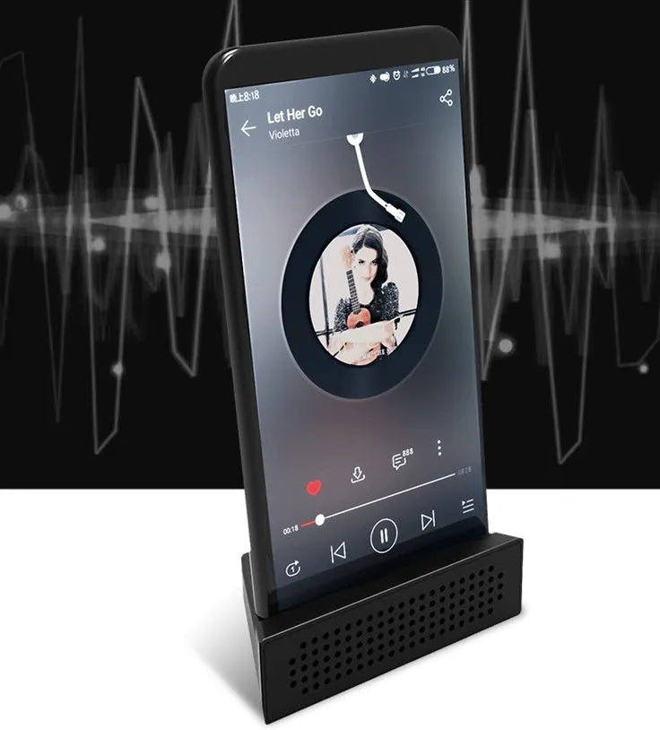 Mini black ABS plastic mobile phone amplifier bracket holding a smartphone on a desktop.