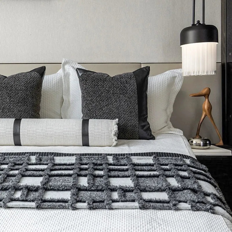 Modern minimalist grey and white plaid bed runner blanket with matching pillowcase and round leather pillow