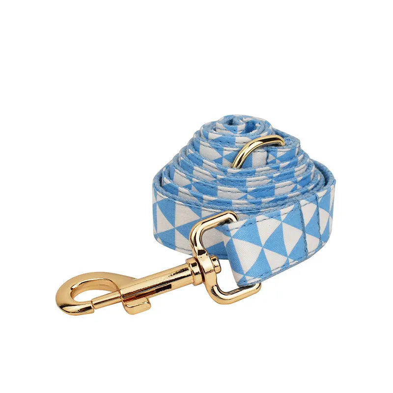Blue cloth dog collar, leash, vest, and decorative bow four-piece pet accessory set.