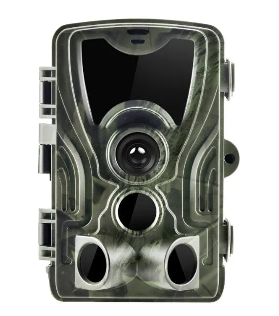 Green cellular trail game camera mounted on a tree trunk for remote deer and wildlife monitoring.