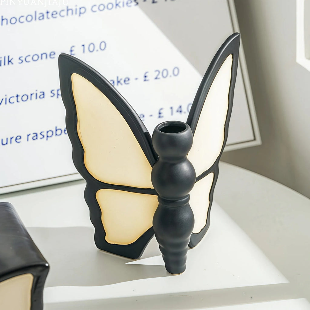 Ceramic butterfly vase and matching tissue box set on a living room table.