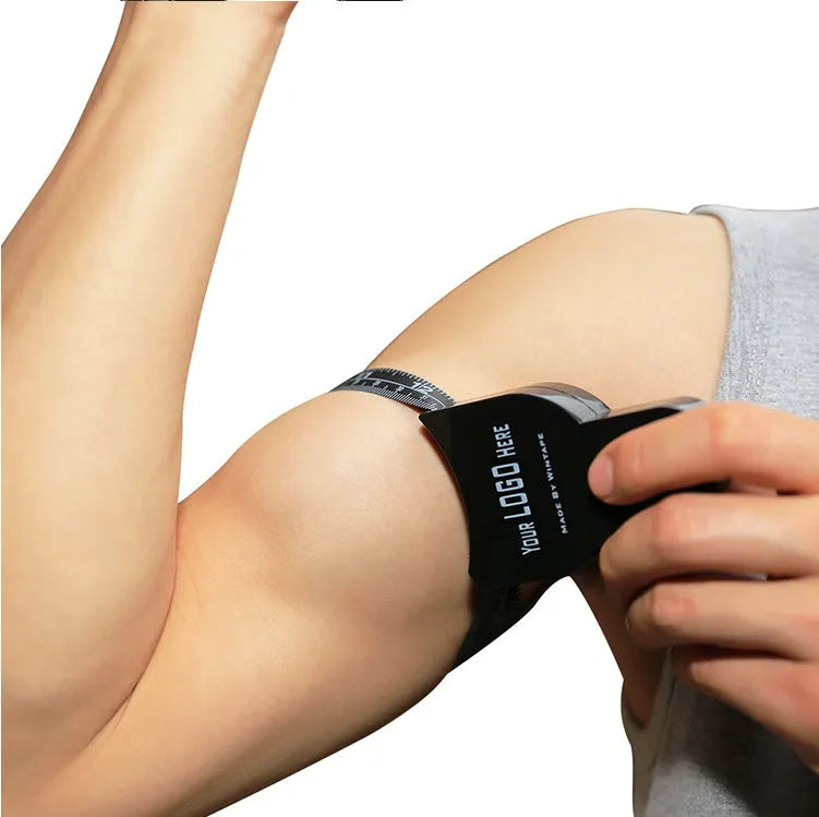 Black ABS plastic body fat caliper skinfold measuring instrument on a tape measure