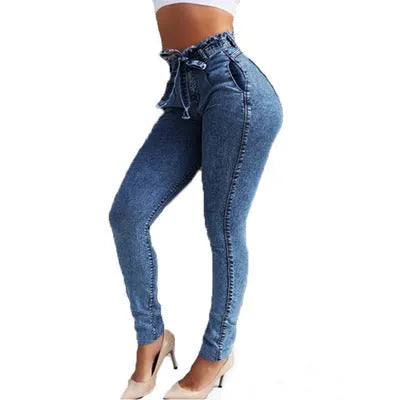 A pair of distressed grey fringed jeans made from Cowboy denim fabric on a neutral background.
