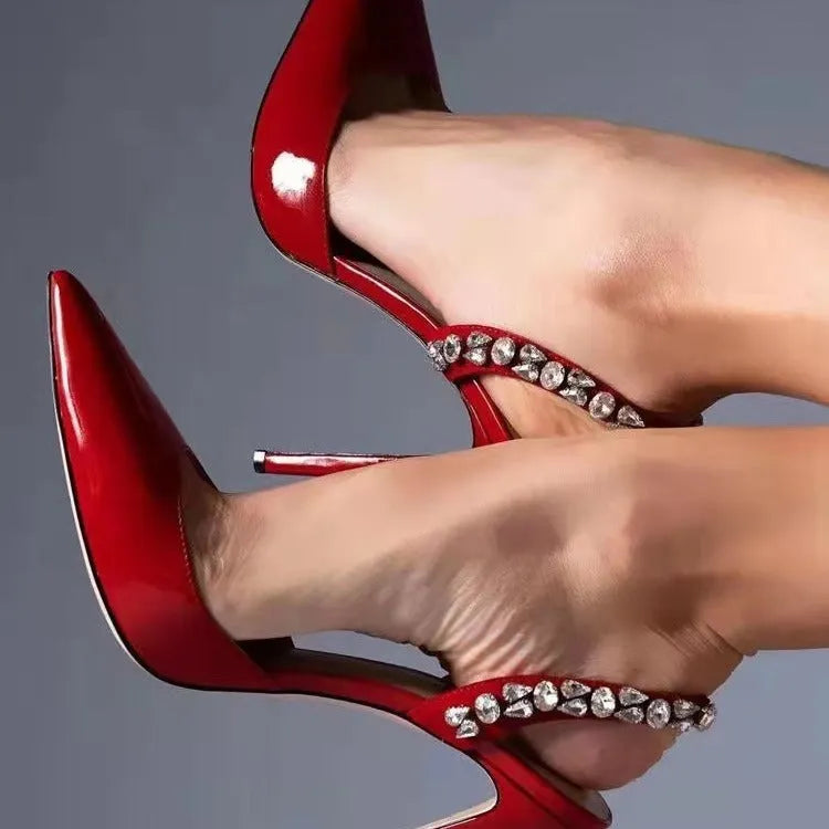 Women's black patent leather pointed toe high heel sandals with rhinestone details on the strap.