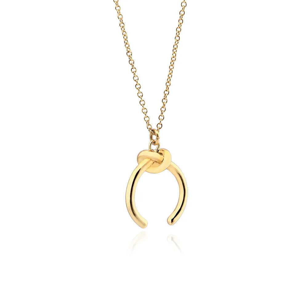 Close-up of a geometric copper pendant necklace with a gold electroplated finish on an adjustable cross chain.