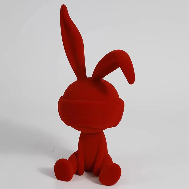 Green suede blindfold rabbit resin table ornament on a wooden desk