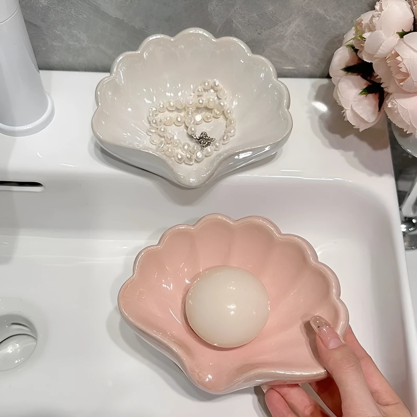 White and pink shell-shaped plastic soap dish on a bathroom countertop