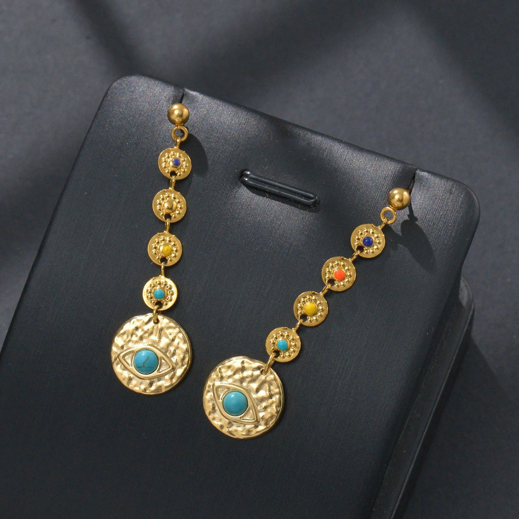 Geometric stainless steel drop earrings showing eight awn star, eye, and shell sun designs
