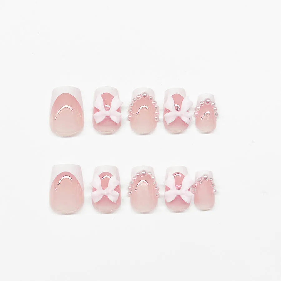 Short white French manicure press-on nails with bow designs and multiple patterns
