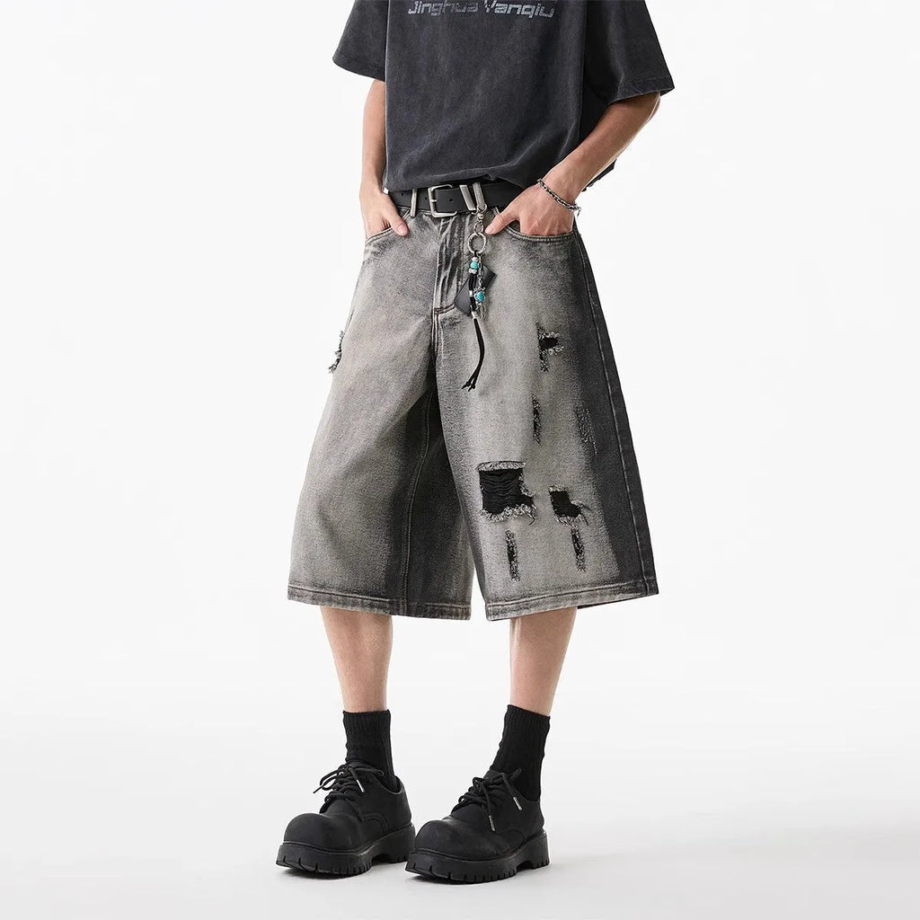 Grey women's denim shorts with a water washed finish, distressed holes, and a loose cropped fit.