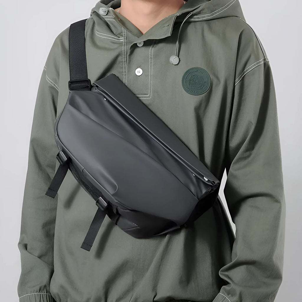 Grey horizontal square crossbody bag for men with a single shoulder strap and zipper.