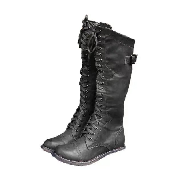 A pair of black chunky heel high leg boots with a round toe on a solid background.