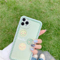 Green TPU iPhone case with a smiley face and polka dot geometric design on a table.