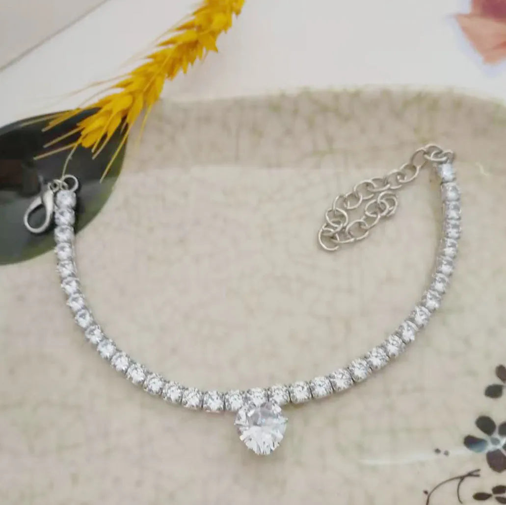 Gold rhinestone heart-shaped collar for a dog or cat on a white background.