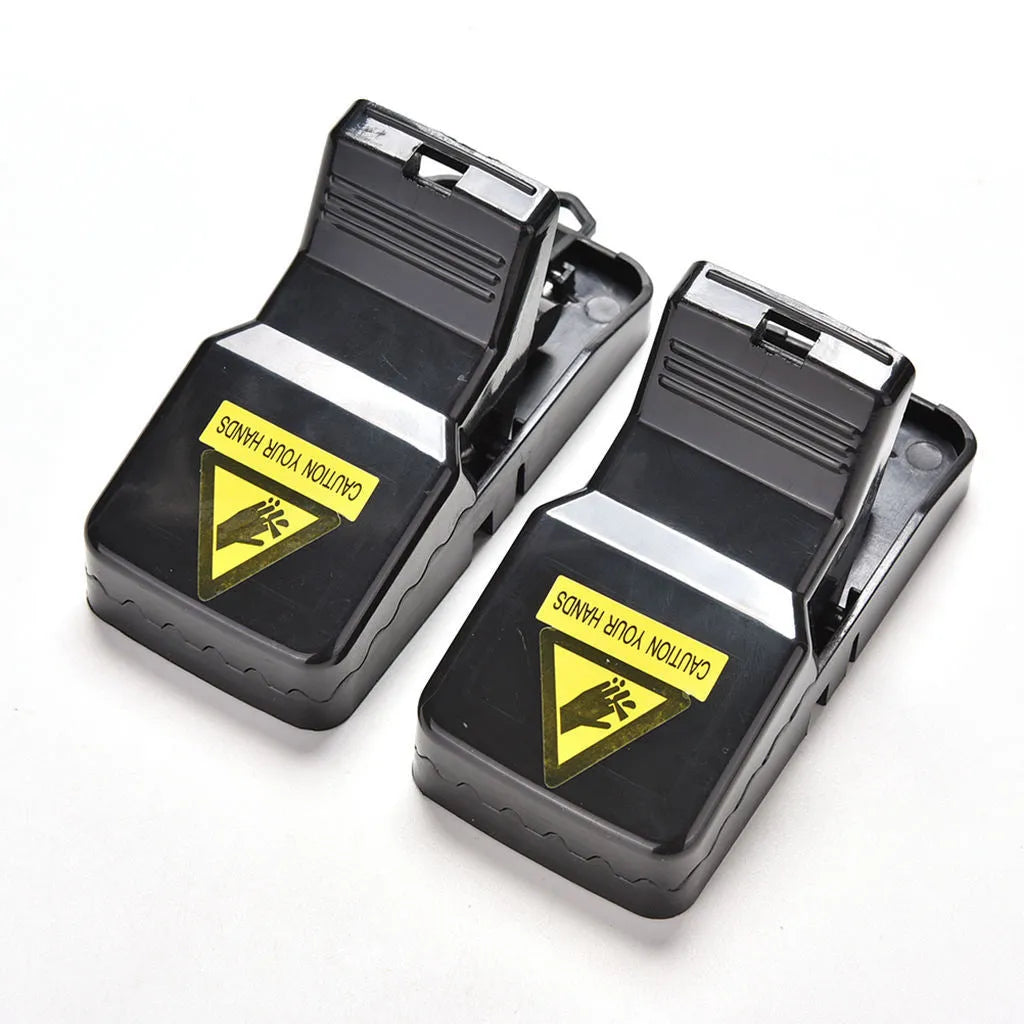 Six black plastic snap mousetraps laid out, each measuring 11 cm long.