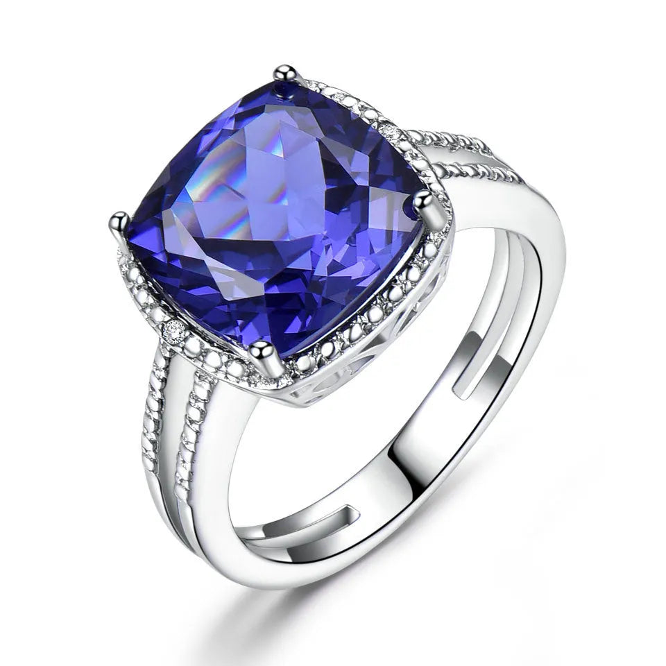 Blue tanzanite gemstone set in a sterling silver women's ring on a plain background.