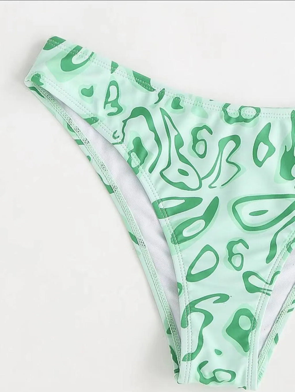 Green floral bandeau bikini with split design and backless styling on swimwear model