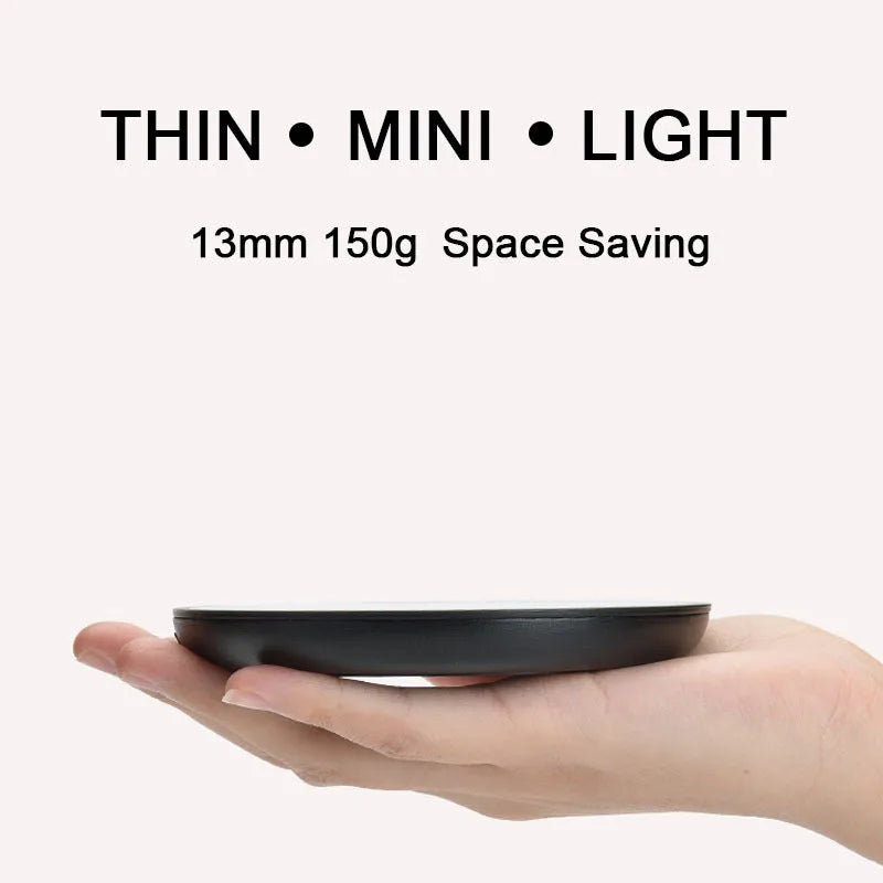 Black circular coffee cup warmer with low and high temperature switch on a desk