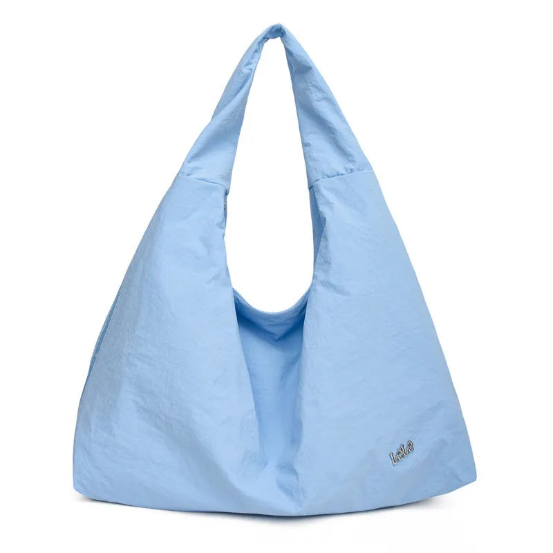 Women's heart-shaped nylon underarm bag in black, shown worn crossbody