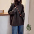 Women's loose grey turtleneck sweater with a thick, textured curling pile collar.