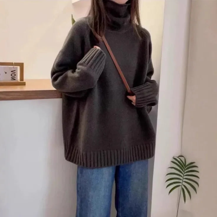 Women's loose grey turtleneck sweater with a thick, textured curling pile collar.
