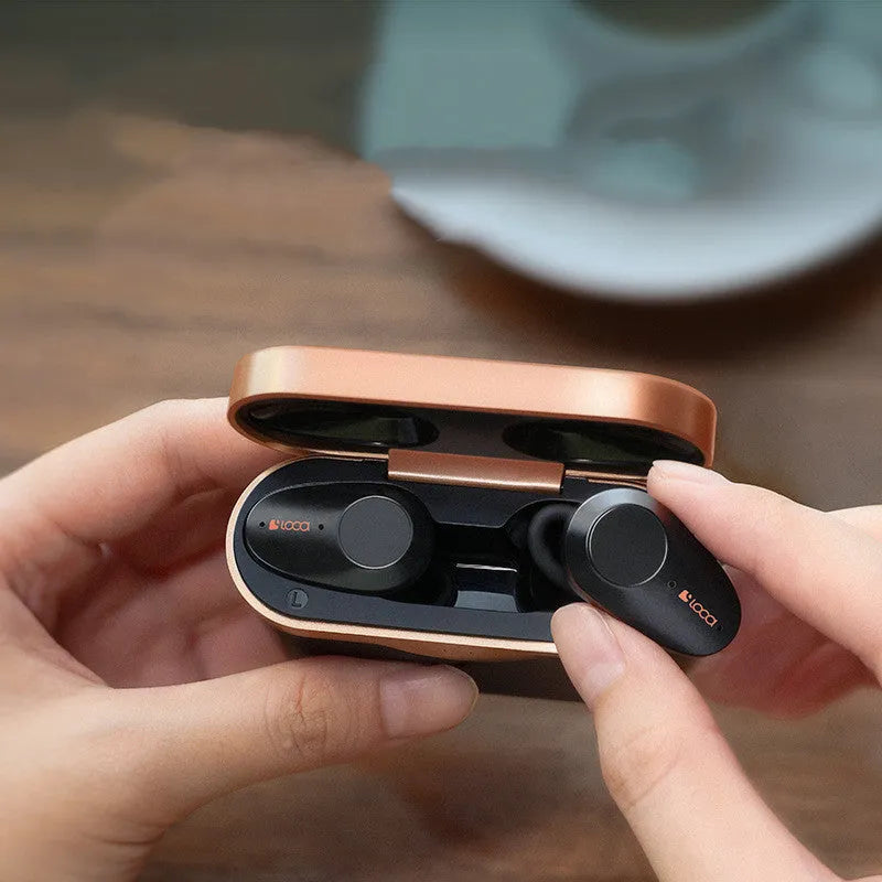 Black wireless Bluetooth headset with charging stand showing earbuds.