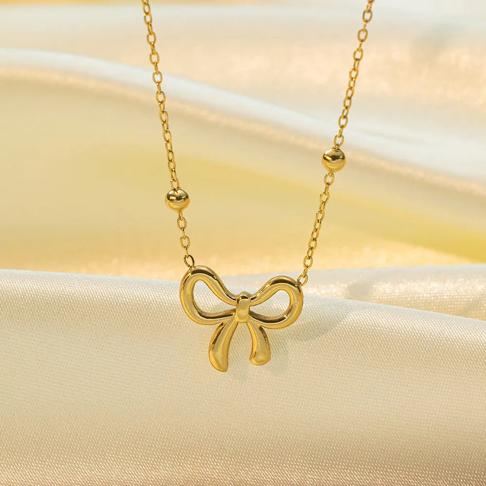 Gold-coloured women's bow necklace with cross chain design on adjustable 41-50cm perimeter