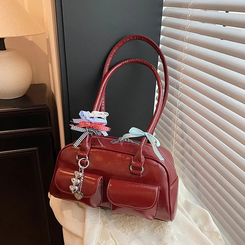 Black retro women's pillow-shaped handbag with double shoulder strap and flap closure.