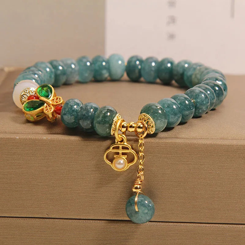 Blue water jade and white agate abacus bead crystal bracelet with rhinestone details and butterfly motif on alloy base