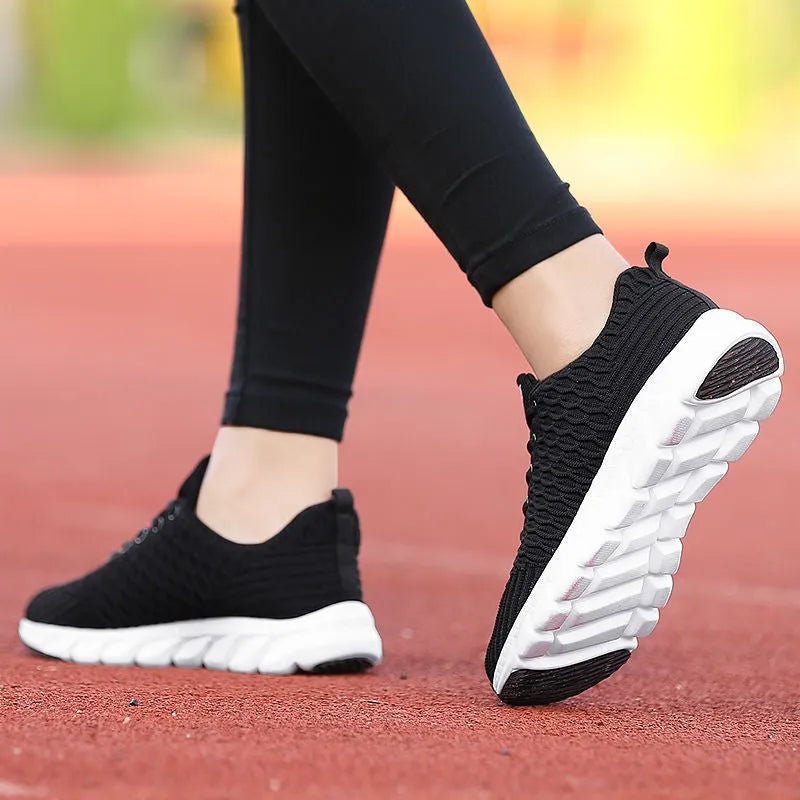 Women's running shoes in black, pink, and white with fly weaving upper and wear-resistant outsole