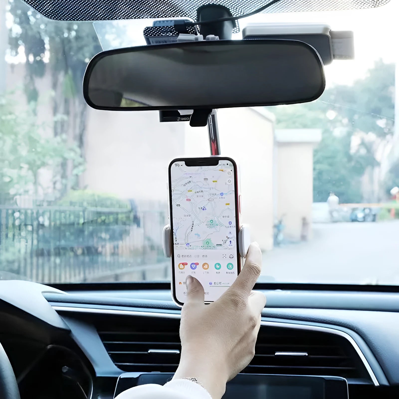 Black mobile phone bracket attached to car rearview mirror holding smartphone
