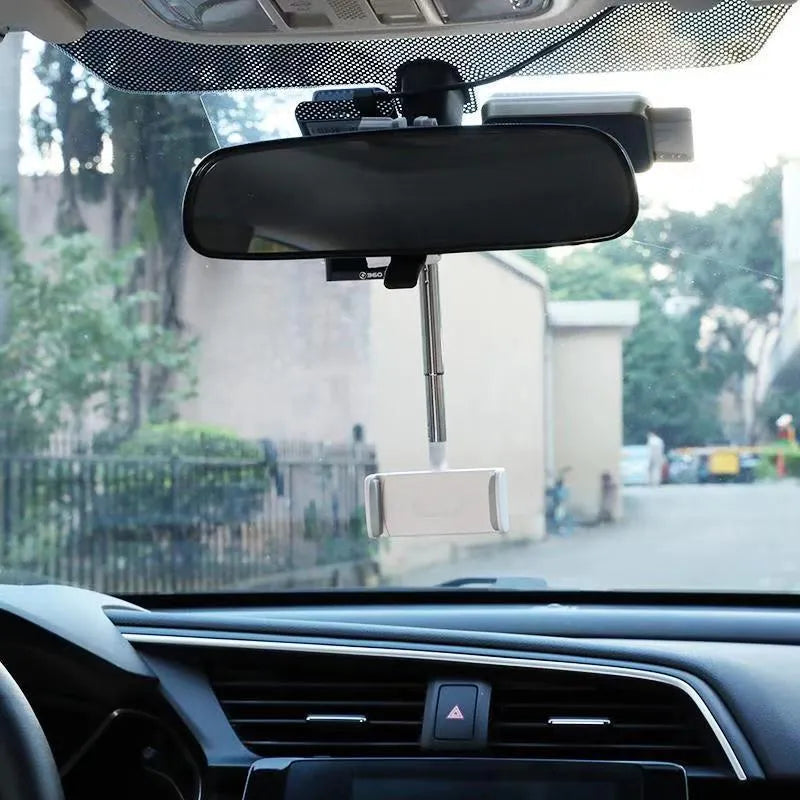 Black mobile phone bracket attached to car rearview mirror holding smartphone