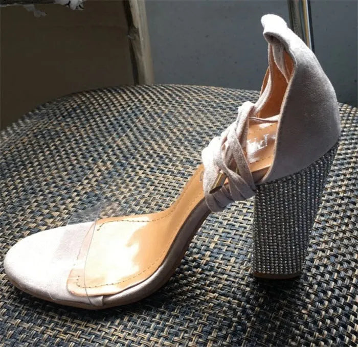 Black and gold plastic women's high heels with pointed toe on a white background
