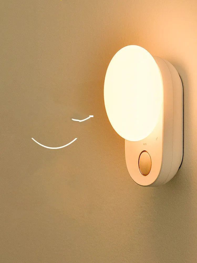 White Baseus rechargeable night light with motion sensor on a bedside table.