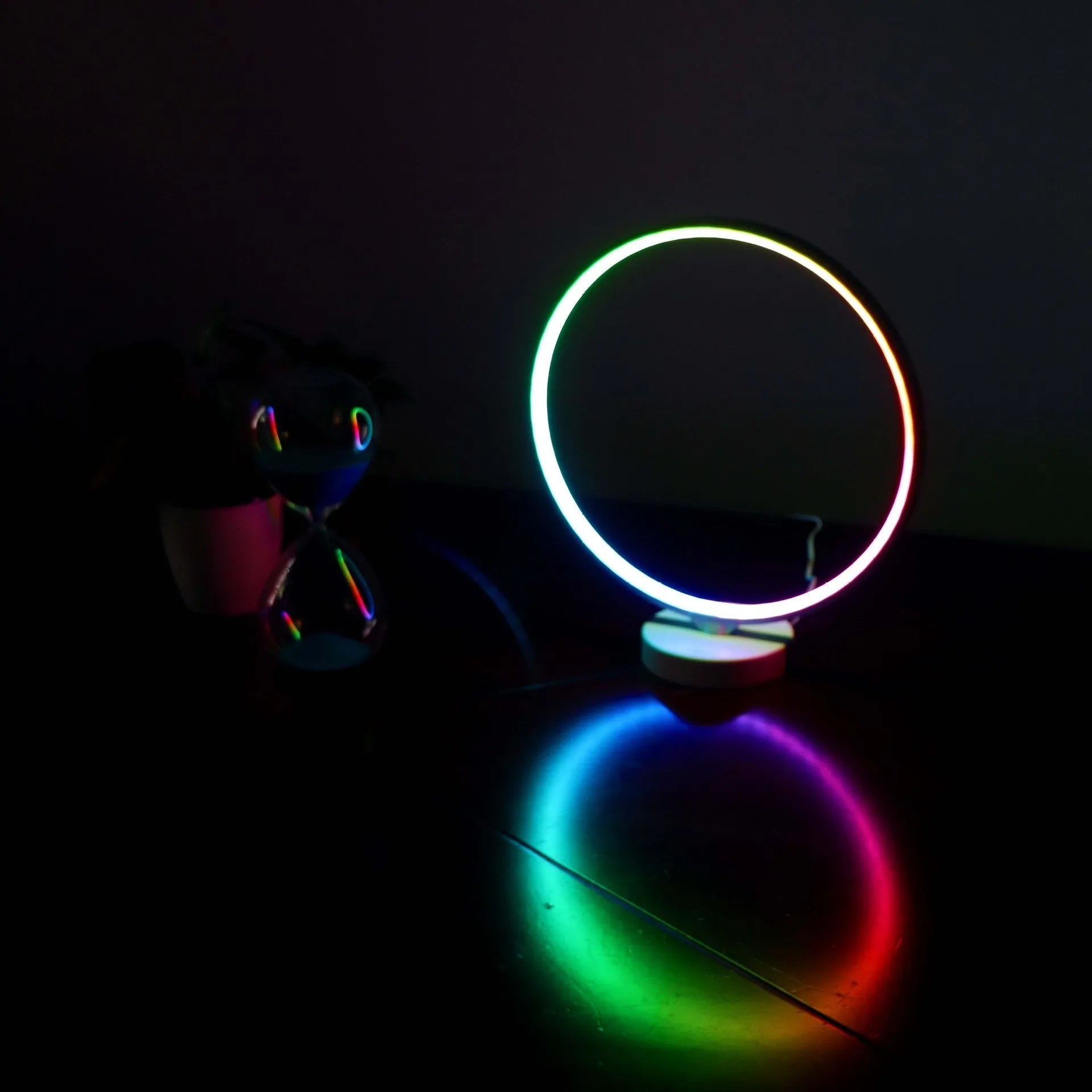 White full moon shaped table lamp with soft glow, placed on a surface with remote control.
