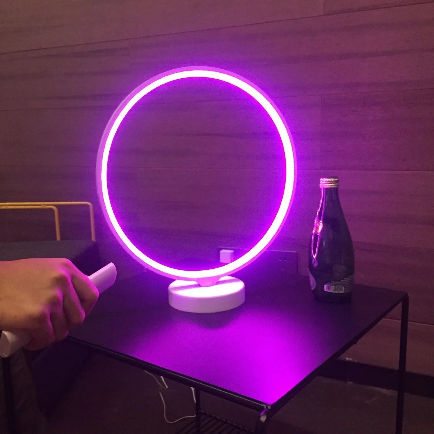 White full moon shaped table lamp with soft glow, placed on a surface with remote control.
