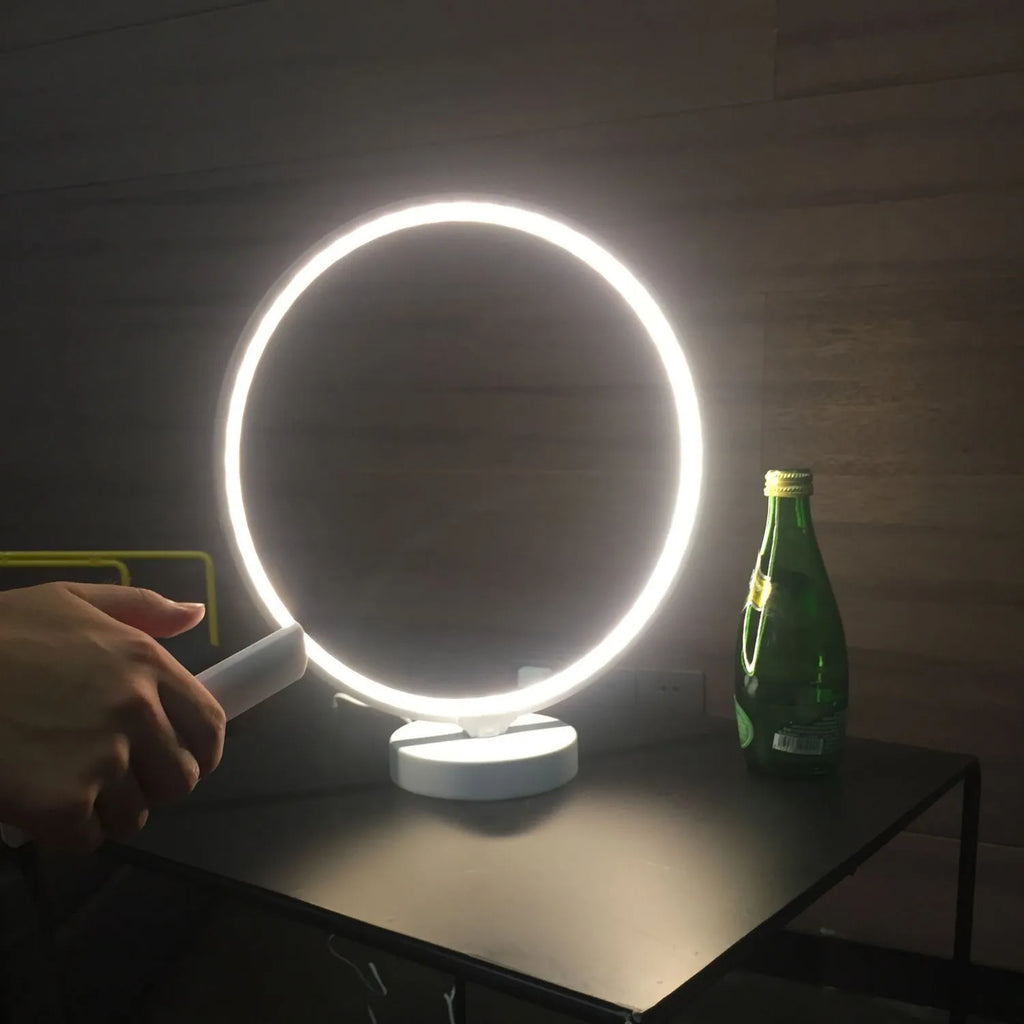 White full moon shaped table lamp with soft glow, placed on a surface with remote control.