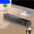 Compact black desktop computer speakers with USB cable connection on office desk