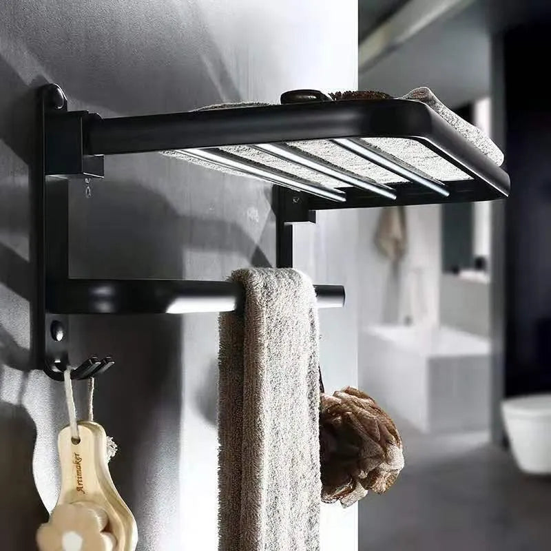 Aluminium double-layer folding bathroom shelf with hooks on a light-coloured wall.