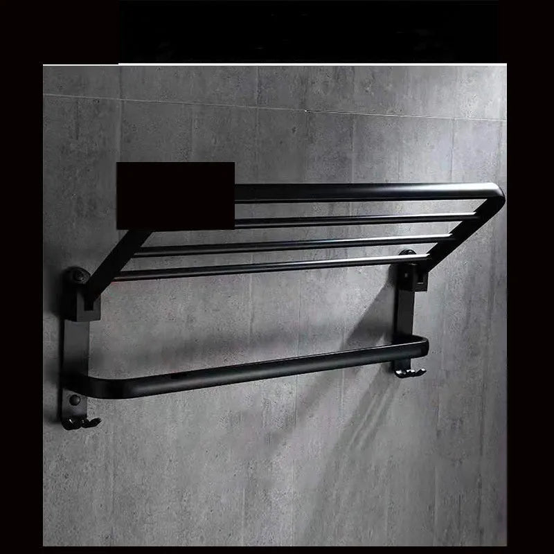 Aluminium double-layer folding bathroom shelf with hooks on a light-coloured wall.