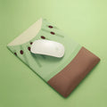 Cute kiwi fruit design mouse pad with a built-in thick grey wrist support cushion on a desk.