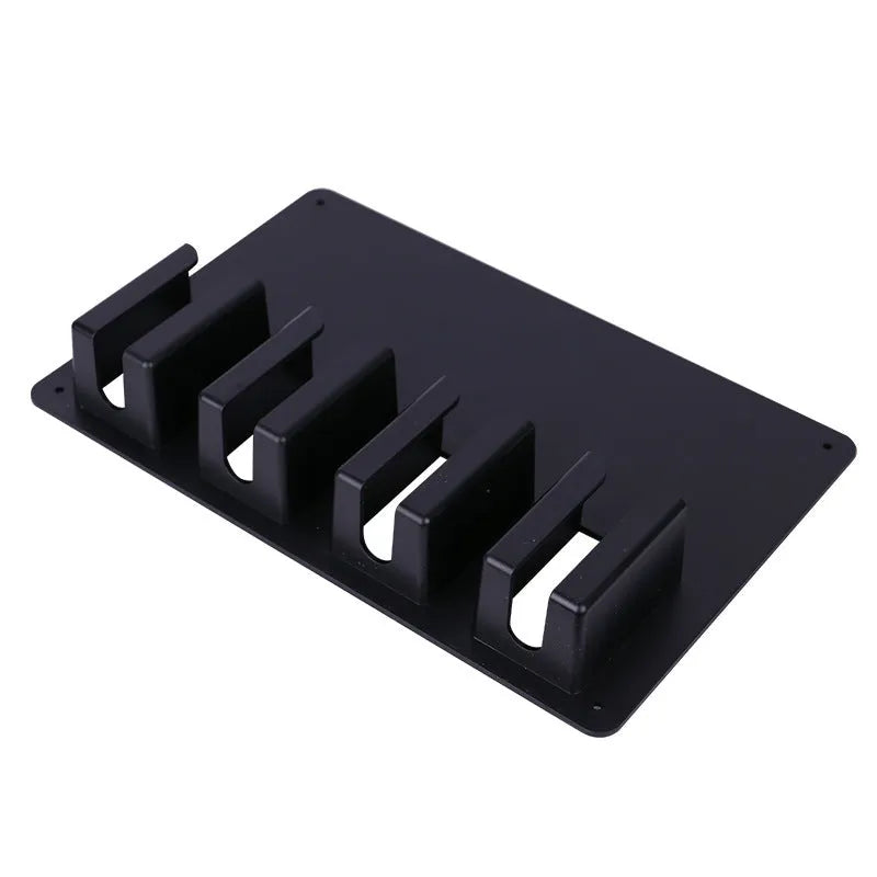 Black plastic wall-mounted frame holding four electric hair clippers