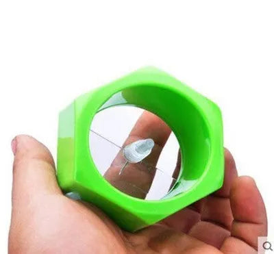 Yellow and green plastic vegetable spiral slicer for cucumbers on a kitchen counter.