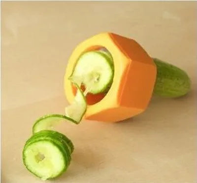 Yellow and green plastic vegetable spiral slicer for cucumbers on a kitchen counter.