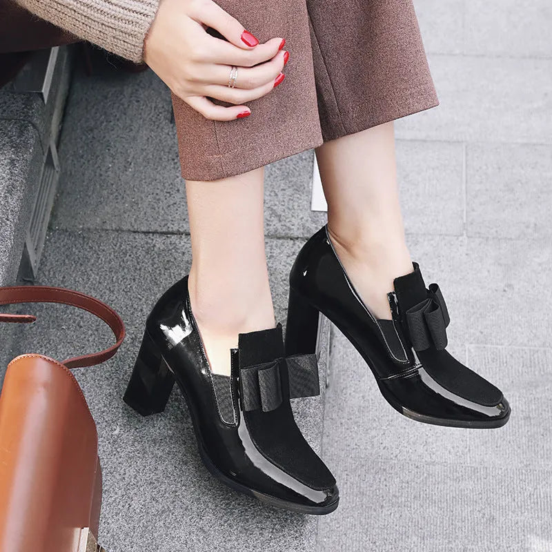 Women's black patent leather high heel shoes with a thick block heel and square toe, shown in a large size.