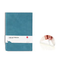 Simple solid colour thickened A5 notebook in green, open on a desk with a pen.