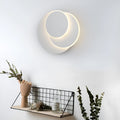 Modern round white acrylic LED wall lamp mounted on a wall