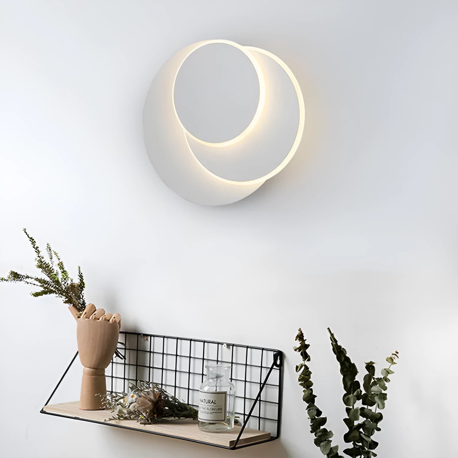 Modern round white acrylic LED wall lamp mounted on a wall