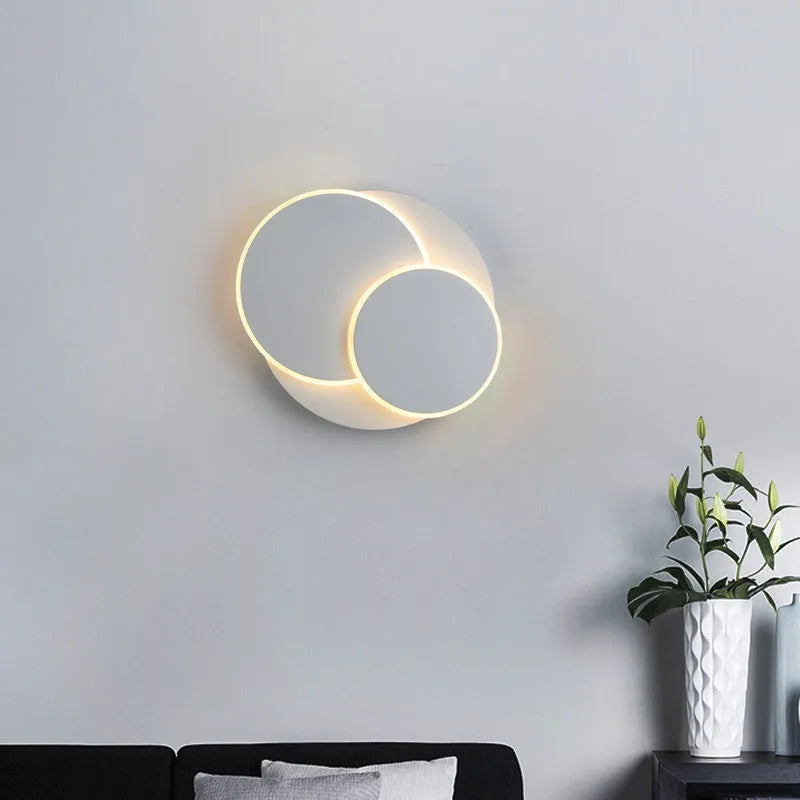 Modern round white acrylic LED wall lamp mounted on a wall